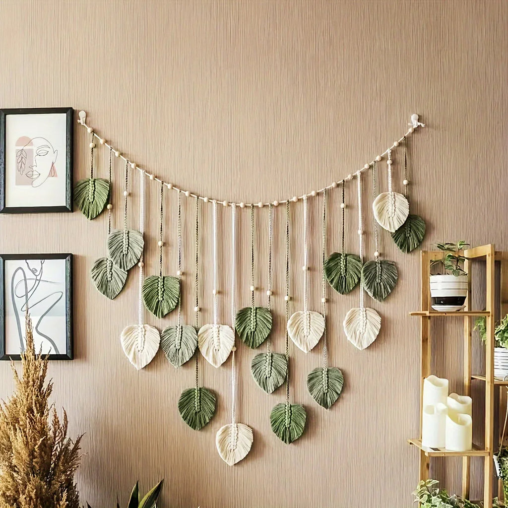 woven green leaf wall garland displayed above framed art and plants