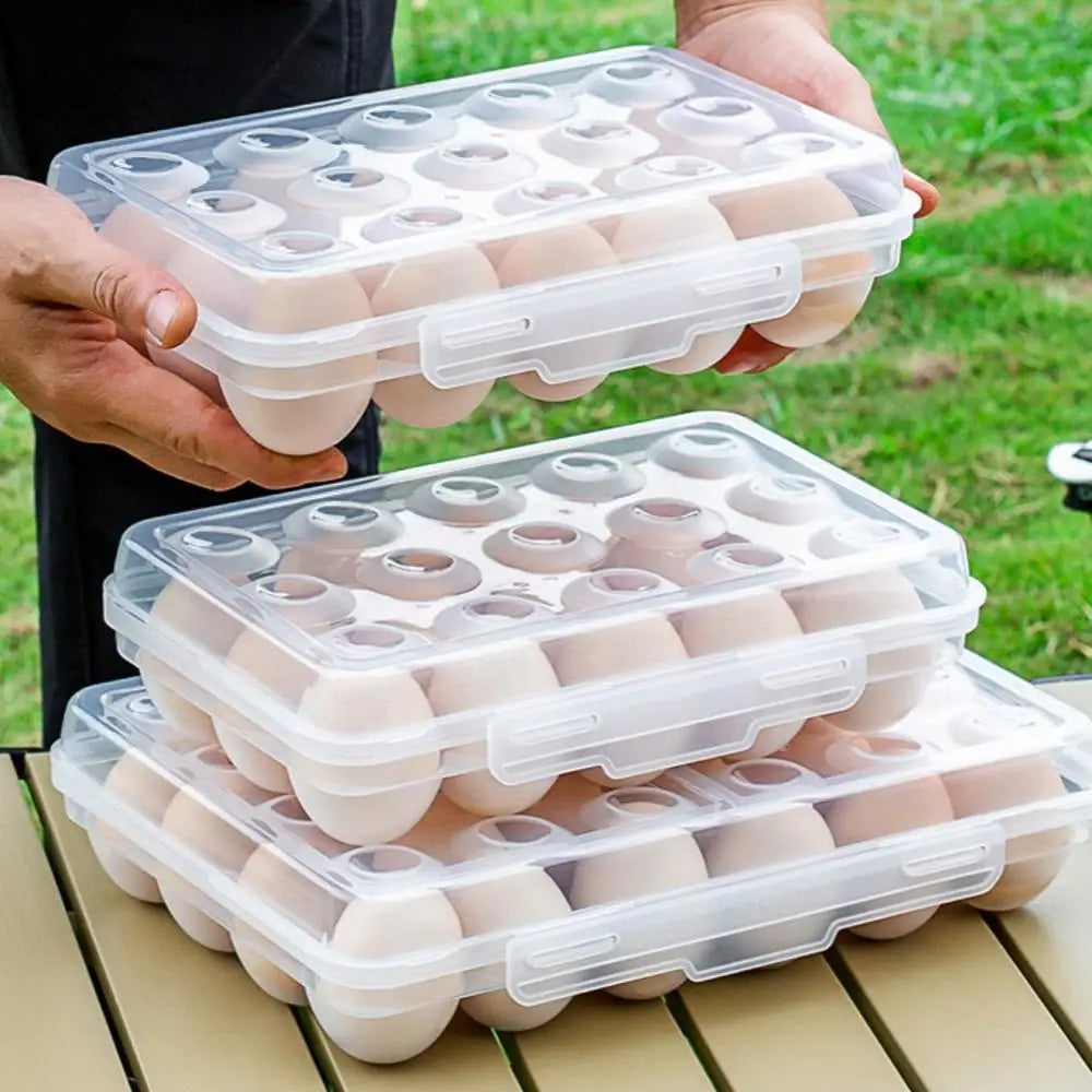 person holding a clear stackable egg tray filled with eggs, with other trays on a table outdoors