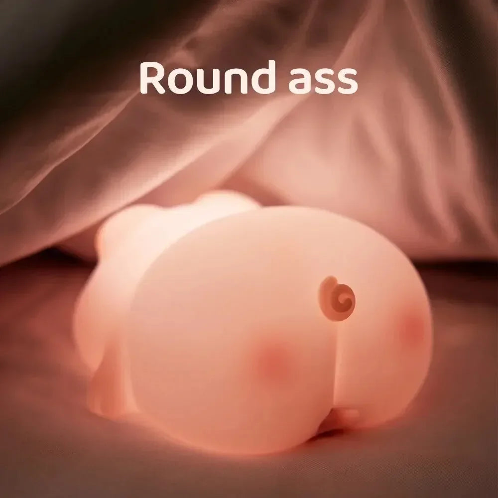 Rear view of piggy silicone night light glowing under a blanket