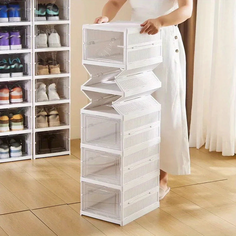 Person assembling tall stack of white shoe organizer boxes with front-opening doors in a living space