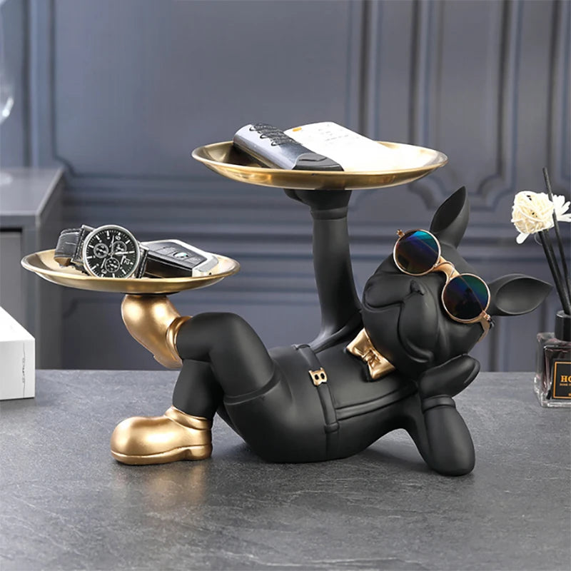 Black bulldog resin tray sculpture holding two trays on a tabletop, styled with sunglasses and assorted accessories
