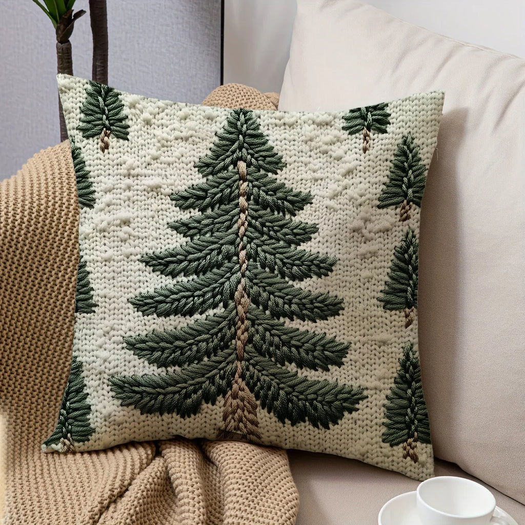 Evergreen tree throw pillow cover on a sofa with a cozy knit blanket and coffee cup