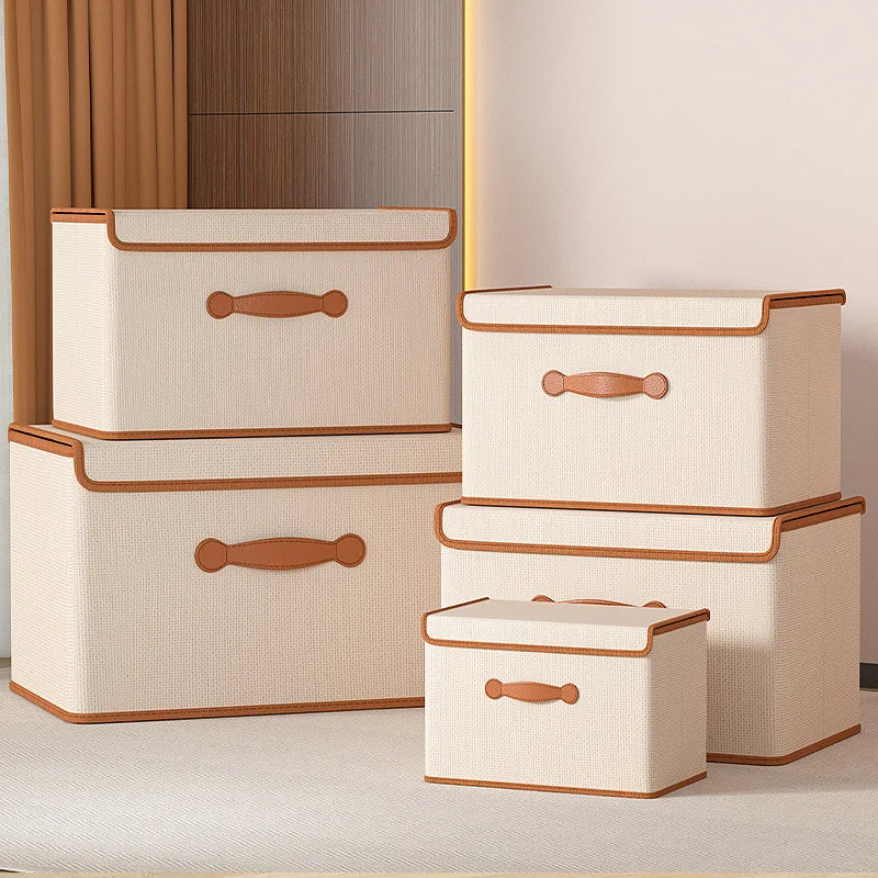 Five beige lidded storage boxes in different sizes grouped in a bedroom