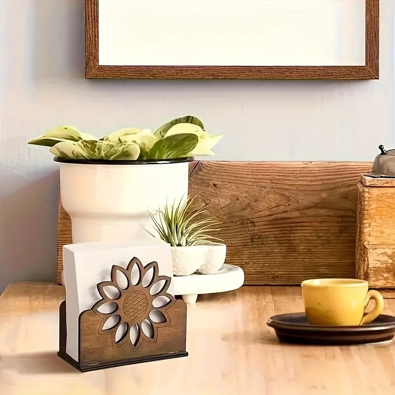 Wooden sunflower napkin holder on a dining table near a cup and potted plants