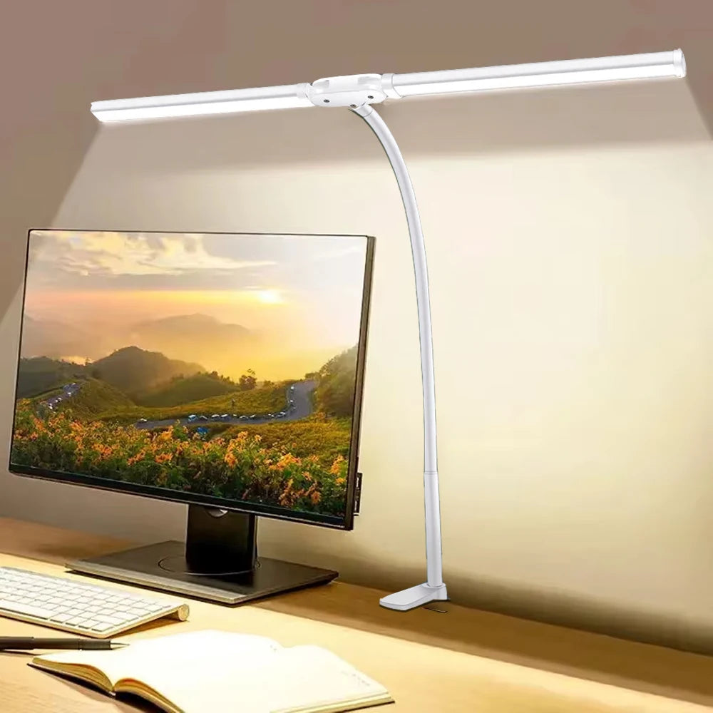 Double-head white LED desk lamp clamped to a desk, lighting a computer workspace