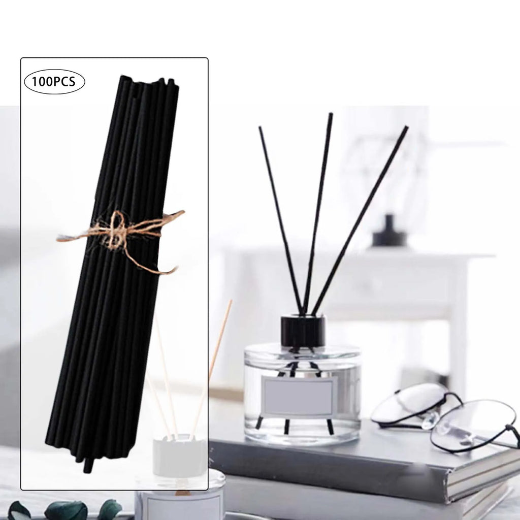 Black reed diffuser sticks bundle and a round diffuser bottle with sticks in a home office setting