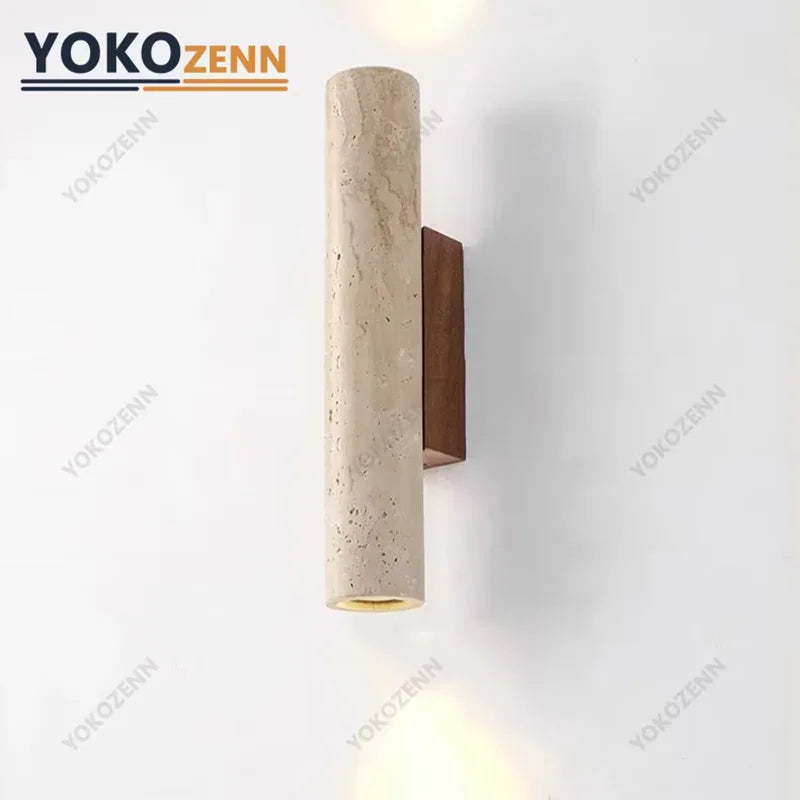 Travertine wall sconce with walnut backplate mounted on a white wall