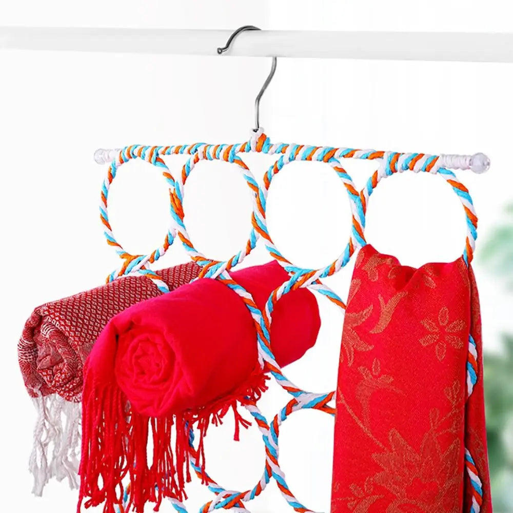 Colorful rattan multi-ring hanger in use, holding rolled and folded red scarves on a closet rod