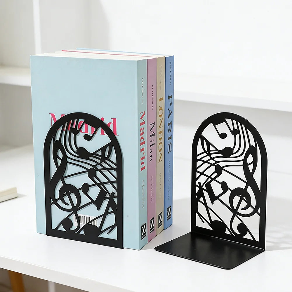 Black metal musical note bookends holding hardcover books on a white desk
