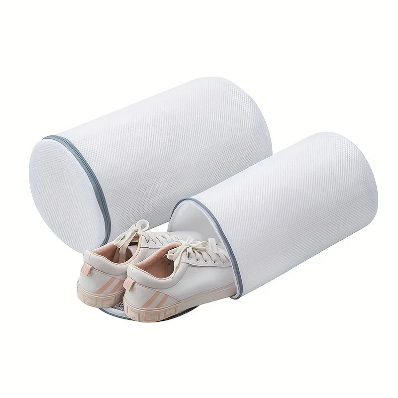 Two pairs of white sneakers inside cylindrical mesh laundry bags with zipper closures