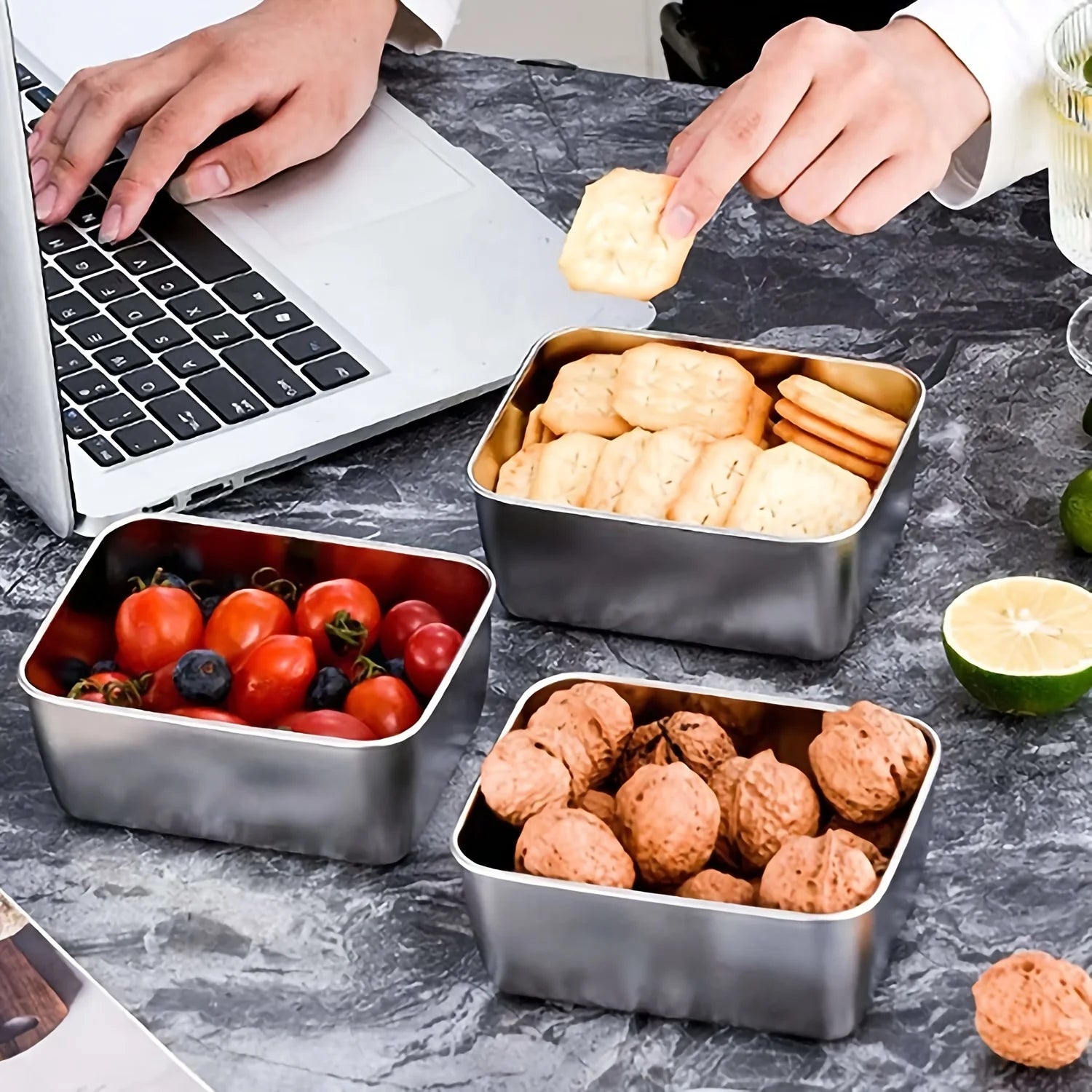 Stainless steel containers used for snacks and berries next to a laptop