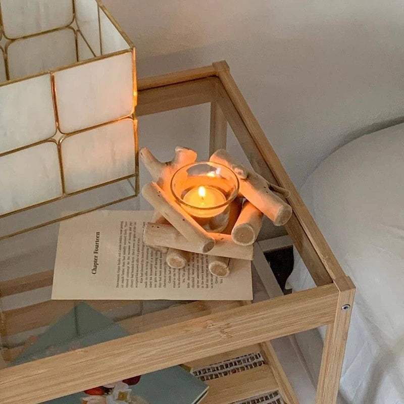 Candle holder with wood log design on glass side table with lit candle