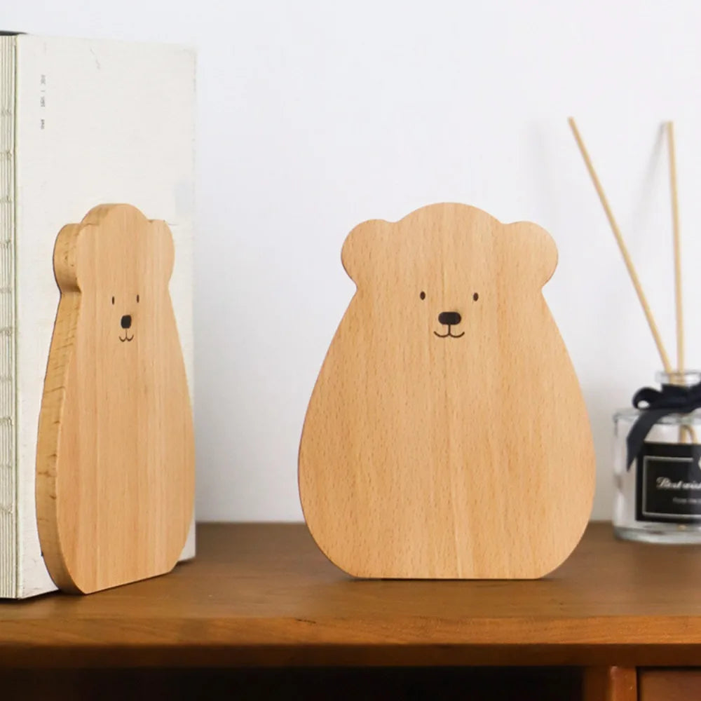Bear shape wooden bookend in beech holding books on a desk