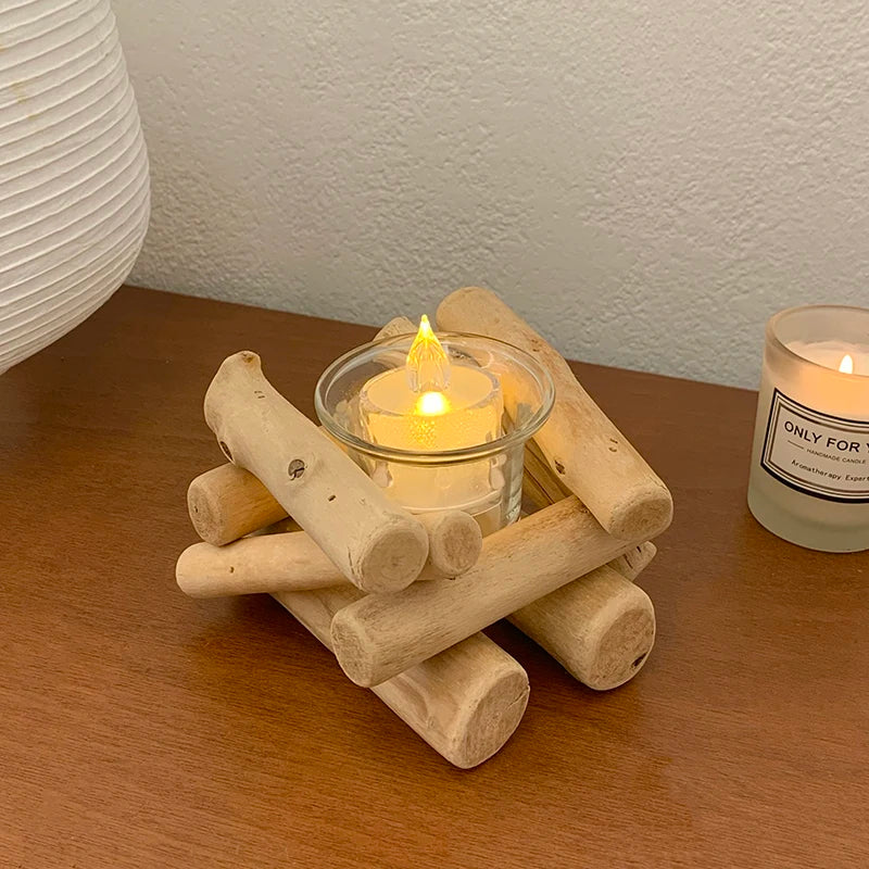 Driftwood candle holder with glass cup and tealight on a wooden table