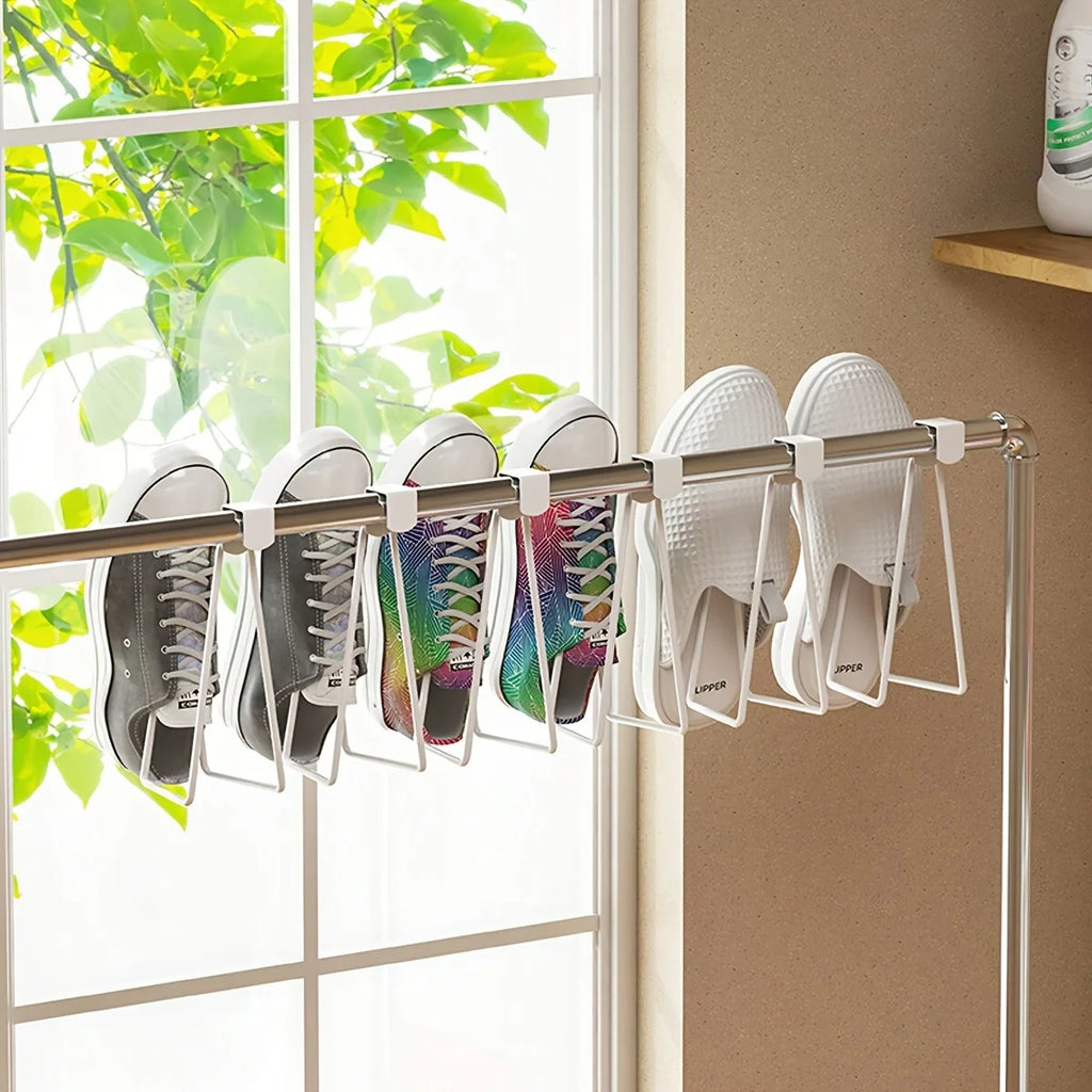 several white metal over cabinet holders being used on a rod to organize shoes by a window