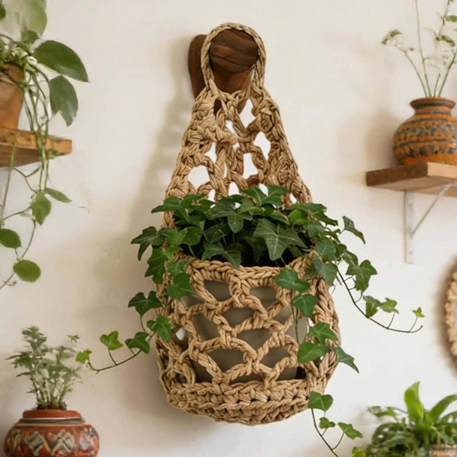 Brown cotton rope macrame hanging plant basket on wall with green ivy