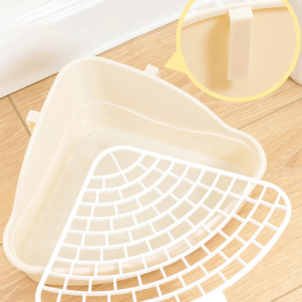 White corner litter tray with removable grid detail on wooden floor