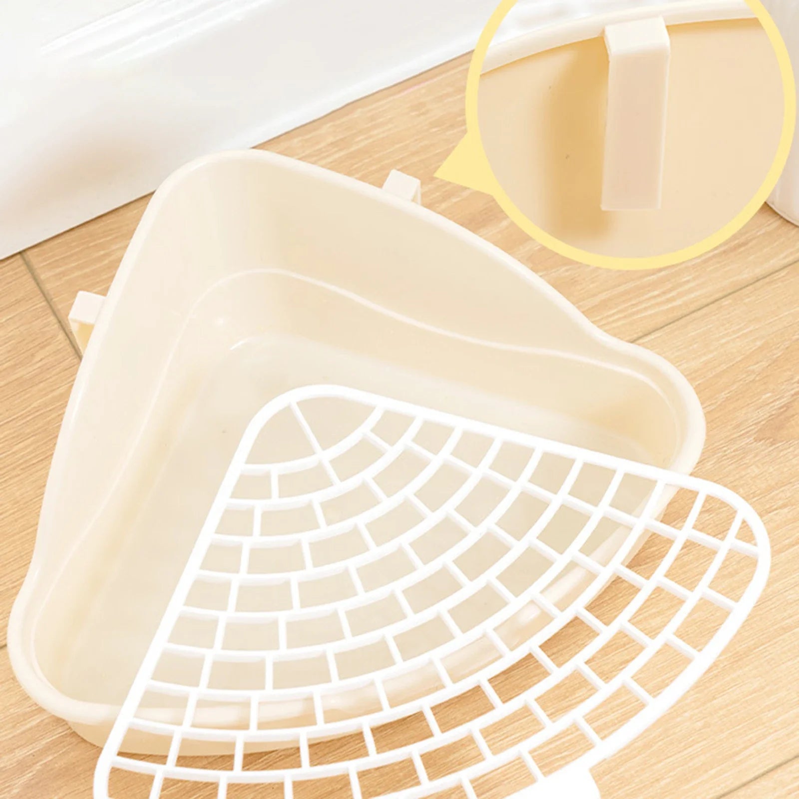 White corner litter tray with removable grid detail on wooden floor
