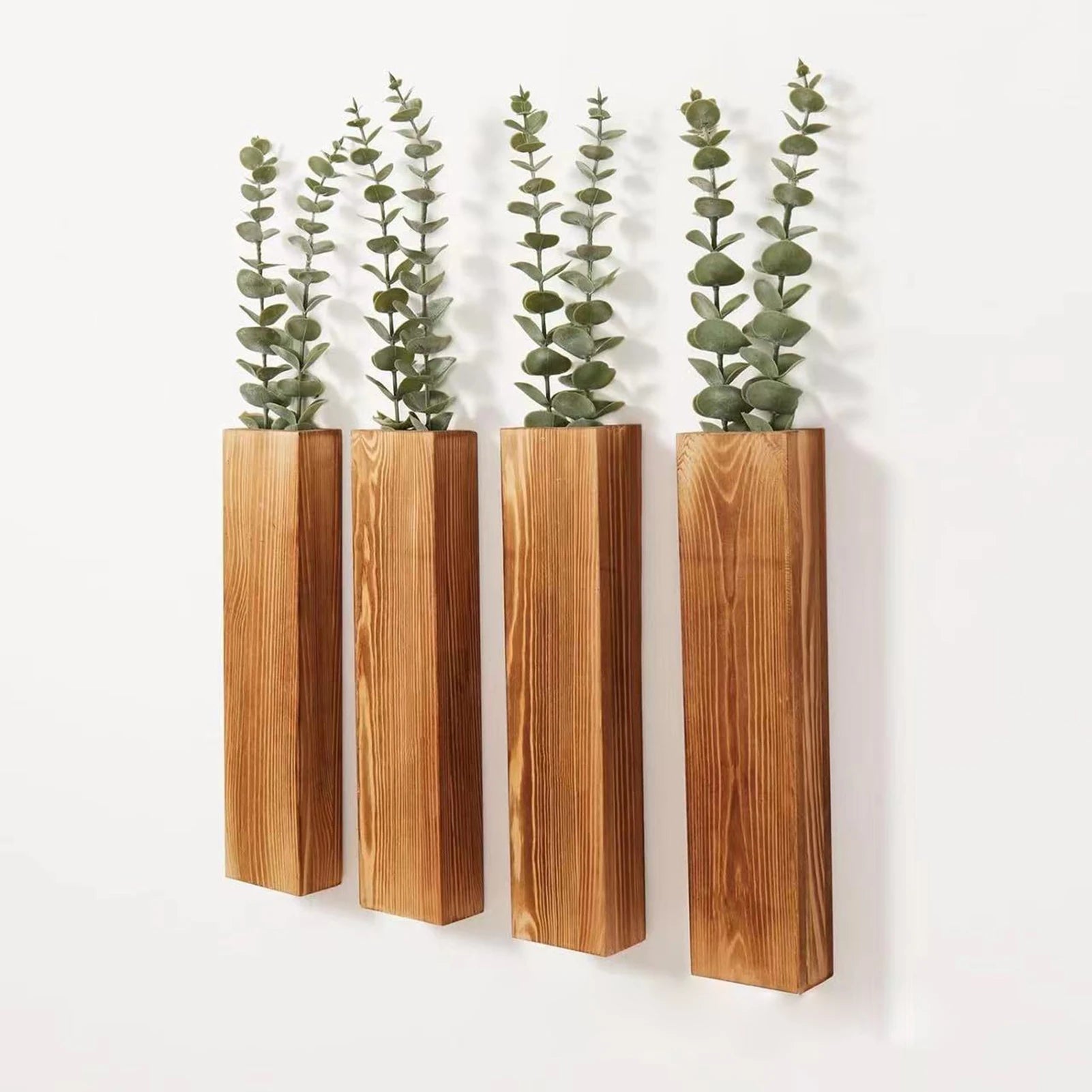 angled view of four wooden wall planters with faux greenery against a white background