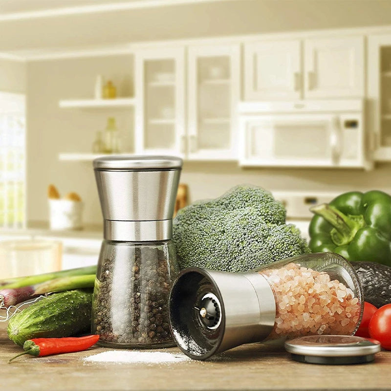 salt and pepper grinders on kitchen counter surrounded by fresh vegetables