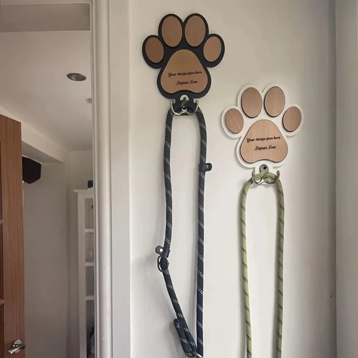 Both black and white paw print wall-mounted leash hooks shown in an entryway, each organizing a different dog leash