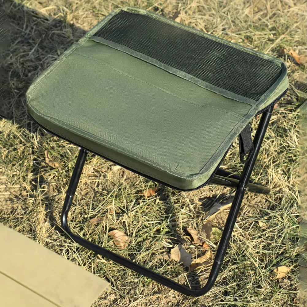 Close view of green folding backpack stool on grass