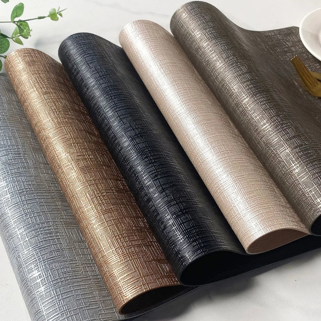 Four metallic textured PU placemats in various colors, rolled and displayed on a light tabletop