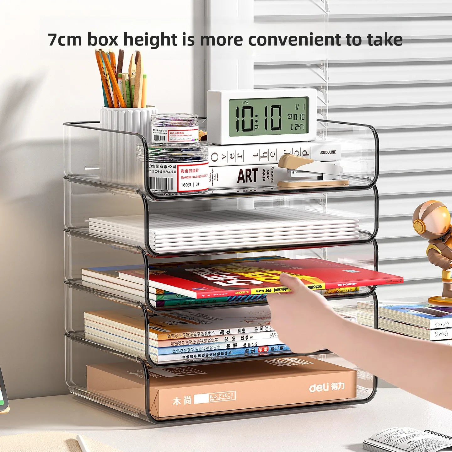 Person placing paper in stackable clear desktop organizer, with four trays