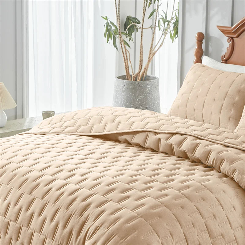 Beige cloud stitch lightweight quilted bedding set with pillow shams on a bed