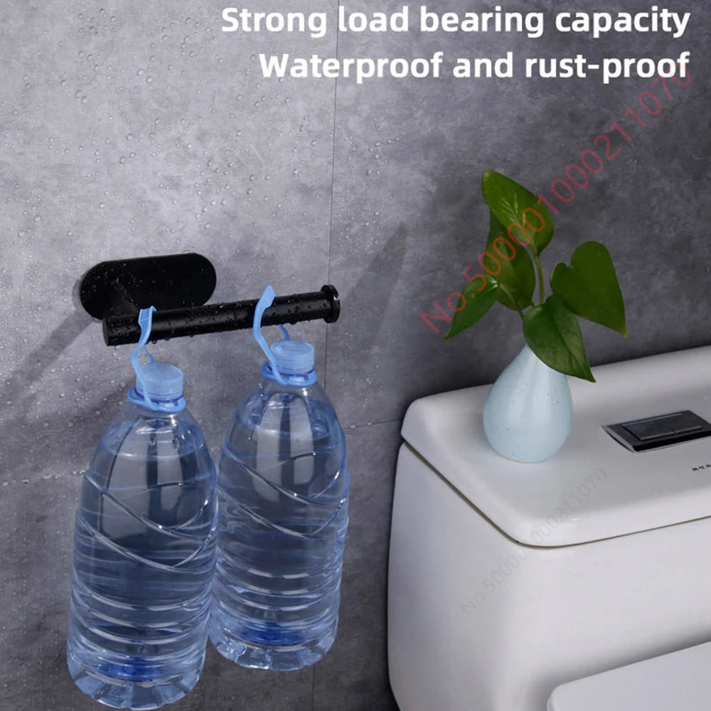 Black adhesive toilet paper holder mounted on tile wall, shown holding two large water bottles for demonstration