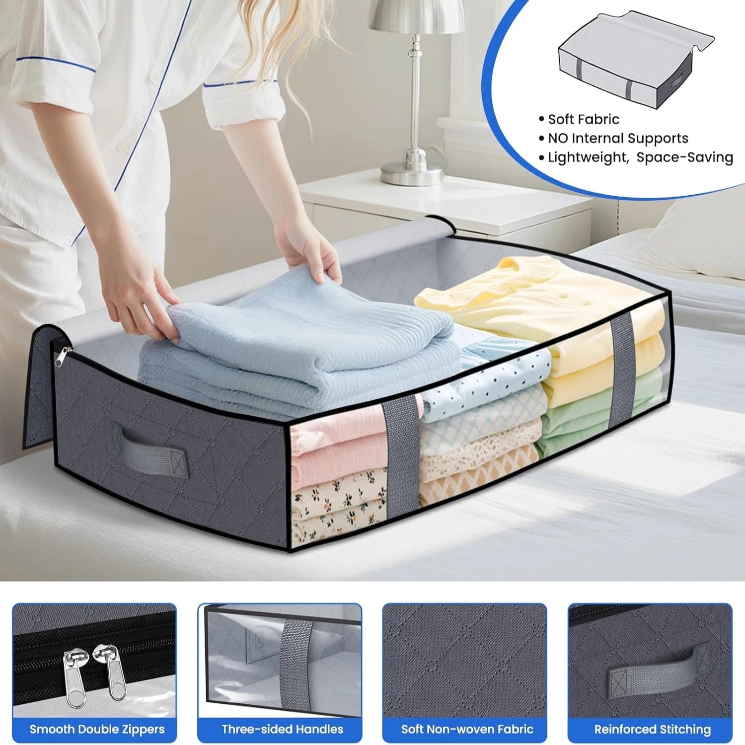 Person placing a folded blue sweater into a grey under bed storage bin with handles and double zippers, informative product callouts below.