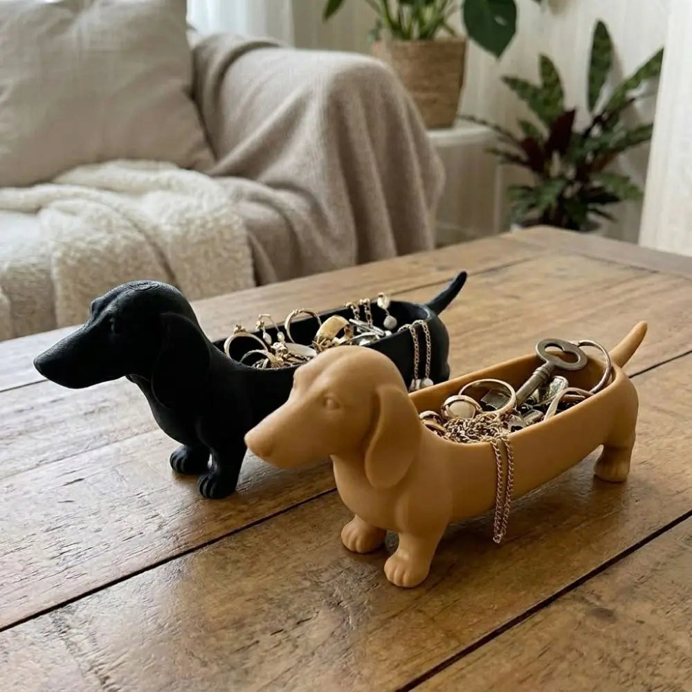 Black and brown dachshund storage trays on a rustic coffee table with jewelry