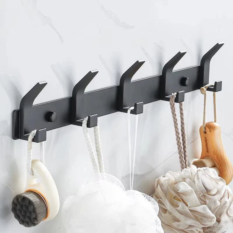 Side angle view of black metal wall hook rack with bath essentials hanging