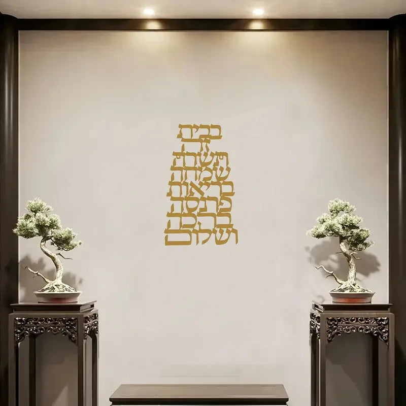 Gold Hebrew letter metal wall decor displayed in an entryway with bonsai plants