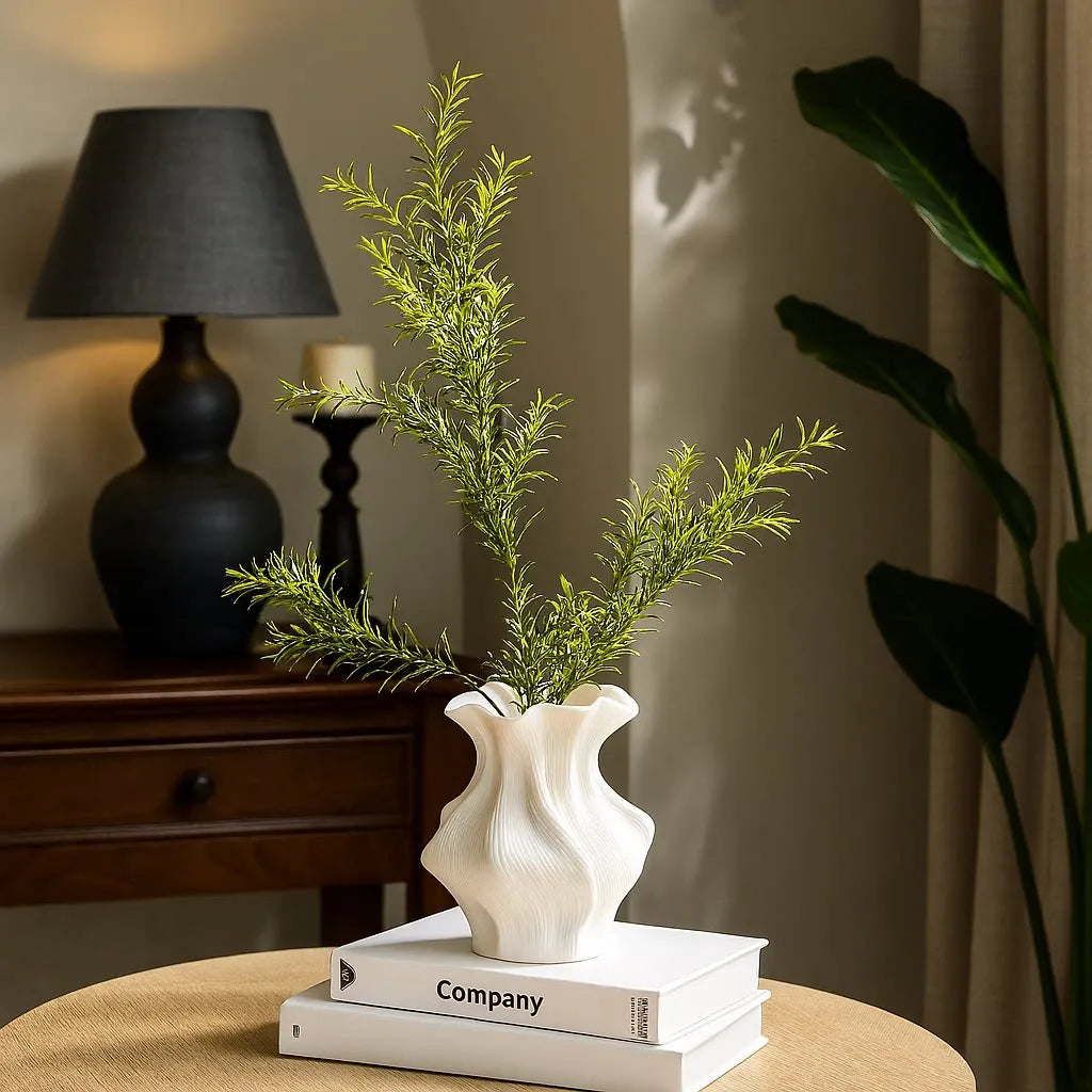 ceramic wave vase styled with green stems on a living room coffee table