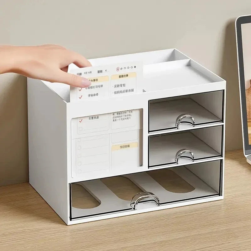 Hand placing a note card into the white desk organizer with multiple empty drawers on a wood surface