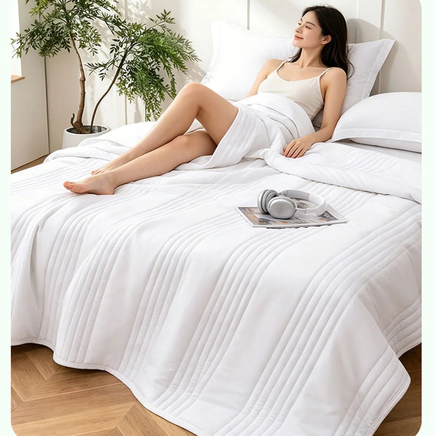 Lightweight summer blanket on a bed, person relaxing, white bedding
