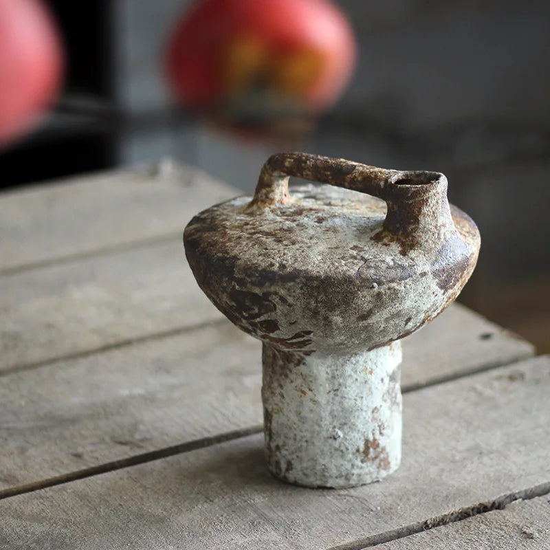 Shorter rustic ceramic vase with wide base and low handle on tabletop
