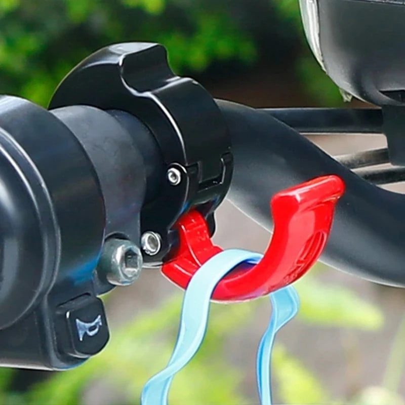 Close-up of a red handlebar hook attached to a bike holding straps