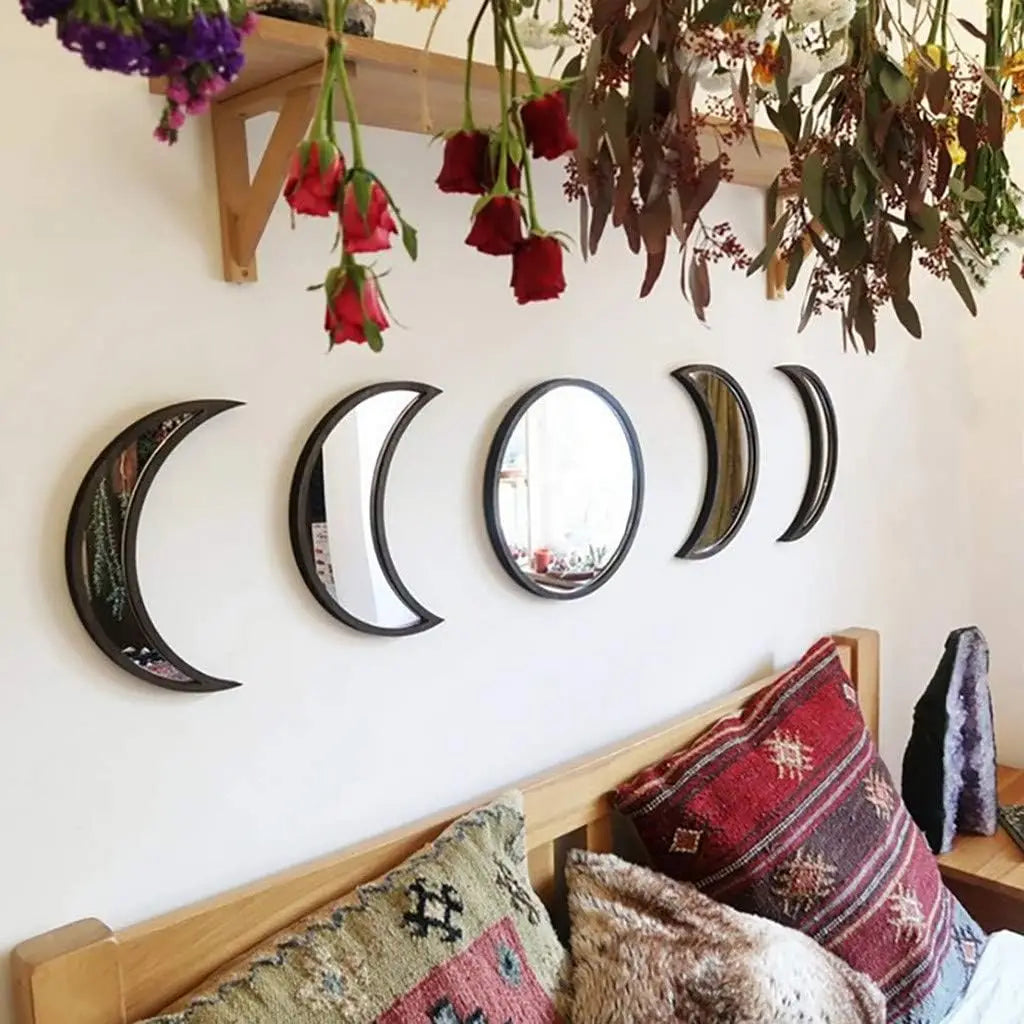 Moon phase acrylic wall mirror set displayed above a cozy bed with boho pillows