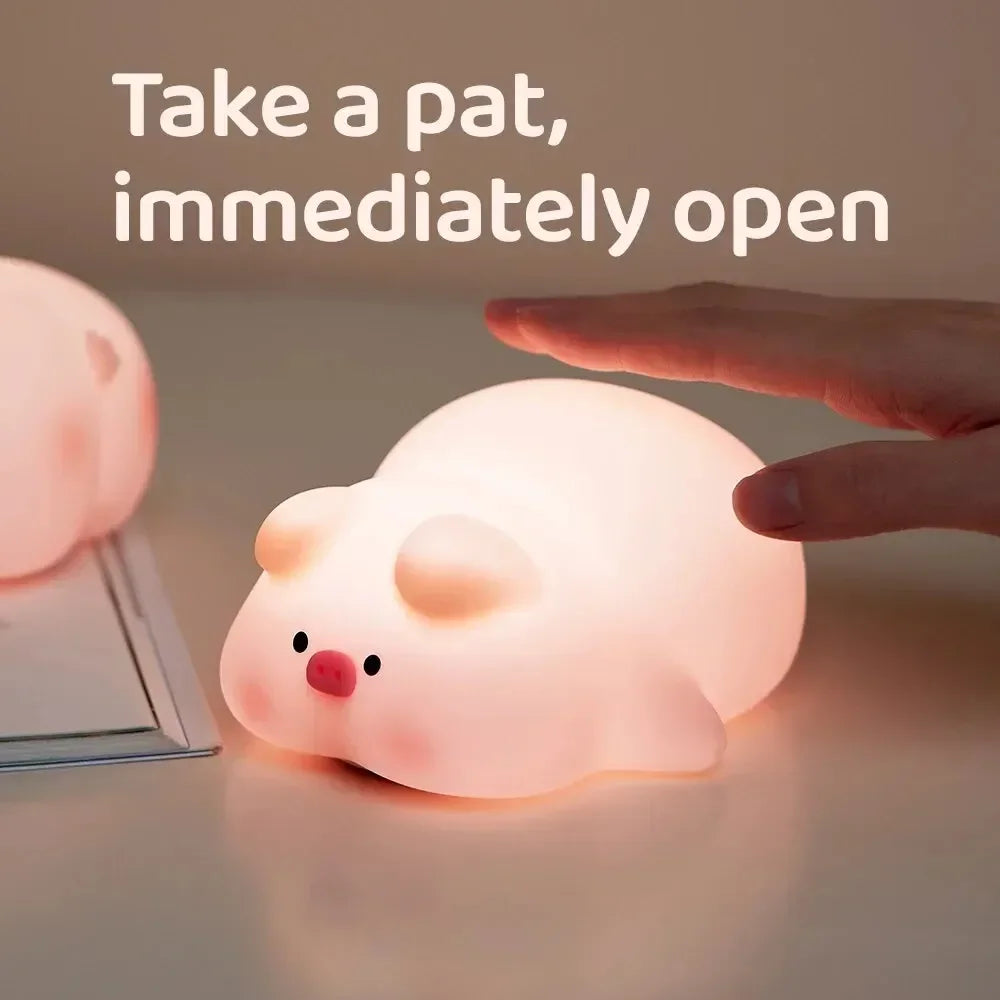 Hand tapping pig-shaped silicone night light on bedside table