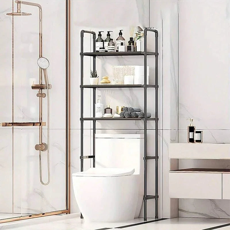 Black freestanding over-toilet storage rack in modern bathroom with three open shelves holding toiletries and towels
