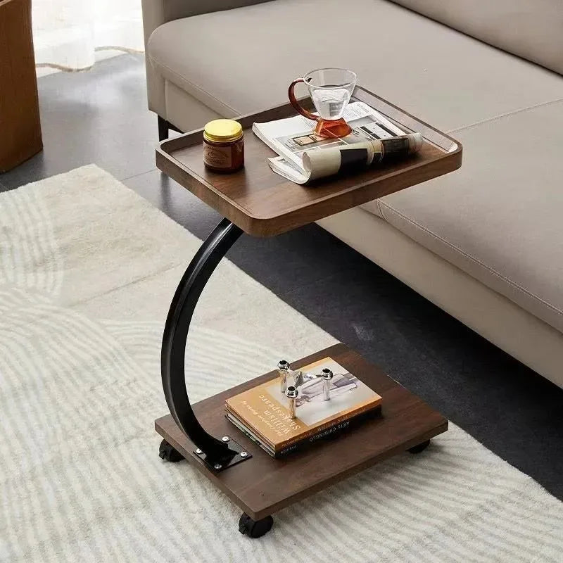 Rectangular rolling side table with books and tea on lower shelf in living room setting