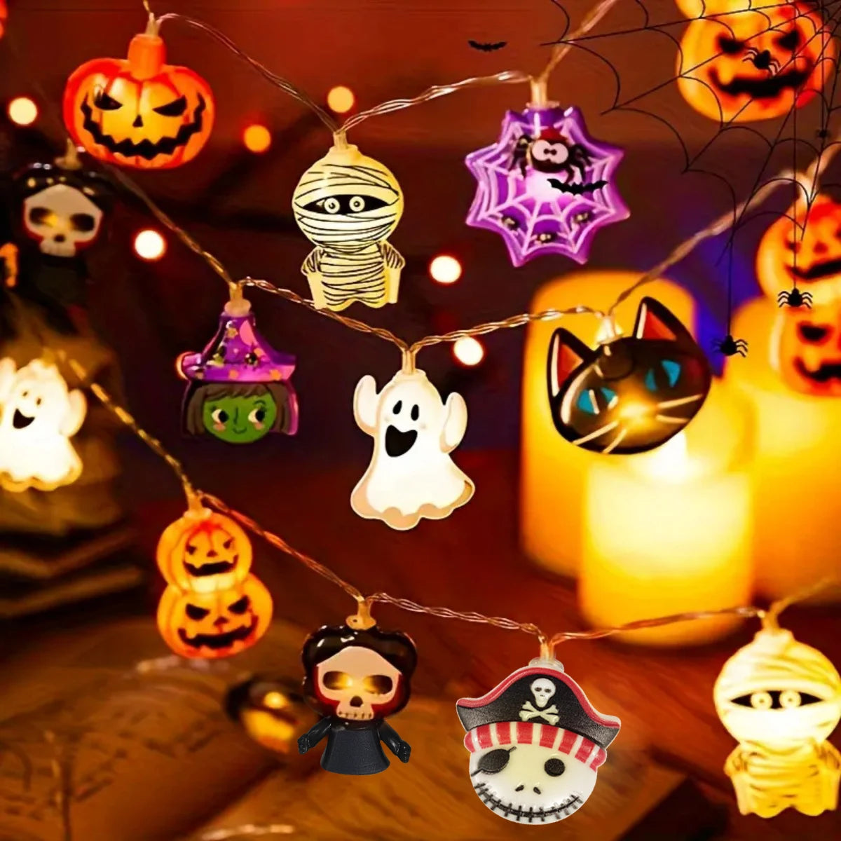 Halloween LED string lights with pumpkin, ghost, mummy, cat, witch, skeleton, pirate, and spider web shapes arranged indoors