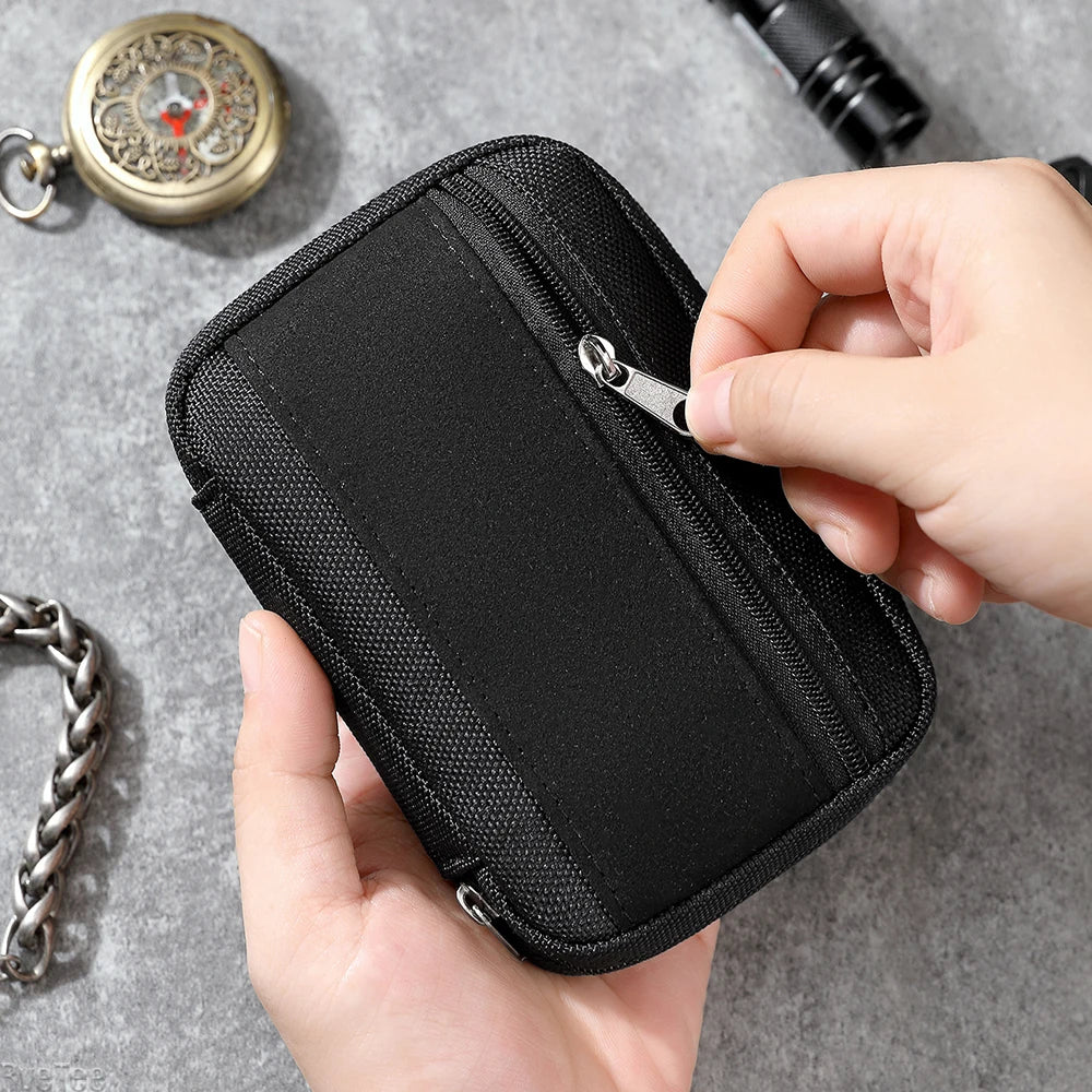 Hand zipping up a black utility organizer pouch with accessories in the background.