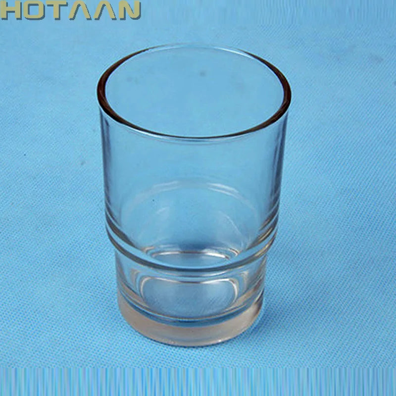 Transparent glass toothbrush cup on blue background