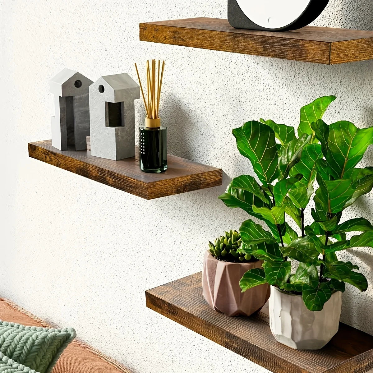 Brown wooden floating shelves on wall styled with plants and decor