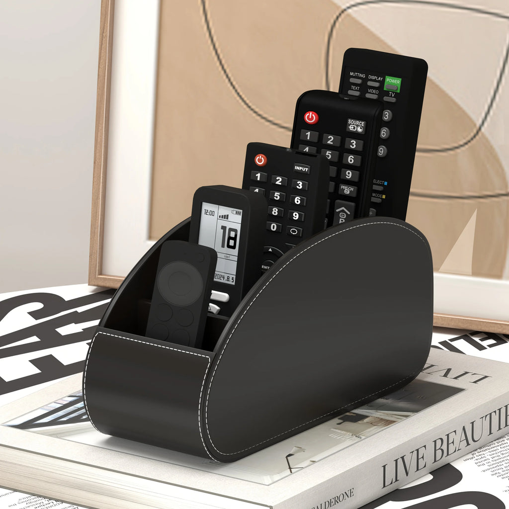 Black remote control organizer caddy with visible stitching, holding remotes on a magazine stack