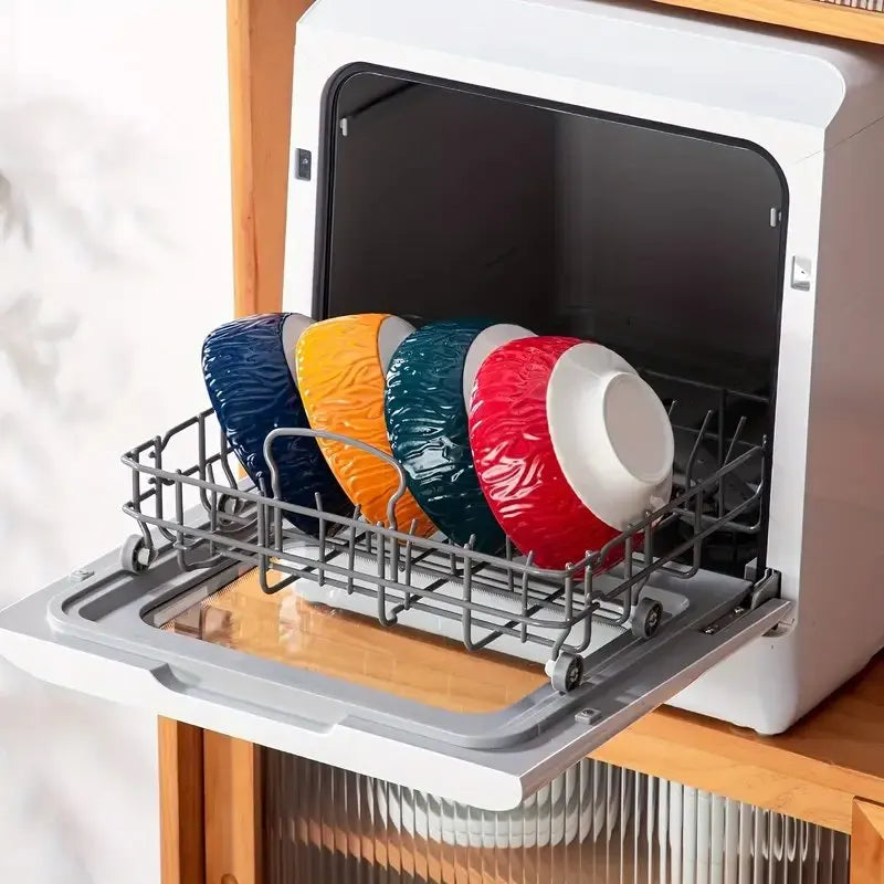 Four Bohemian ceramic bowls stacked in a dishwasher rack, showing red, yellow, blue, and green exteriors