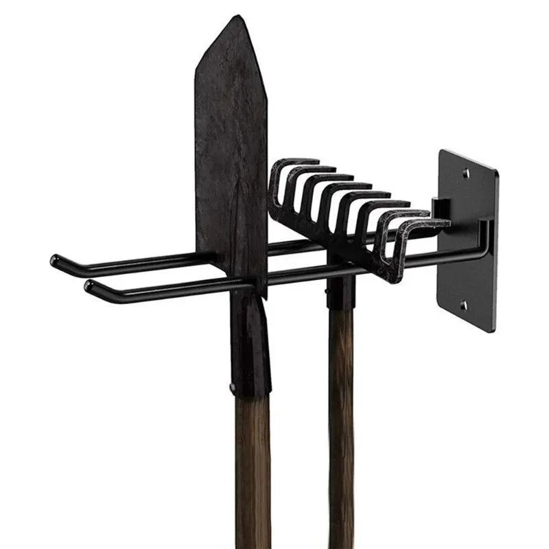 Black iron wall hook organizer holding a shovel and garden rake against a white background